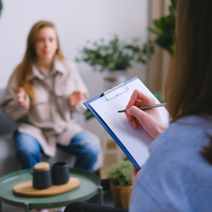 Main d'une conseillère prenant des notes lors d'un rendez-vous de soutien et d'organisation après un décès.